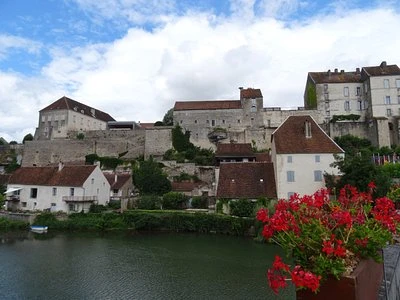 Vue sur les maisons en pierre et les remparts d’Athée au bord de l’eau - Zecamping