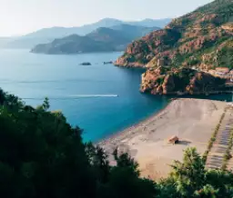 Eaux cristallines de Corse, entourées de falaises spectaculaires, offrant un cadre naturel exceptionnel et sauvage.