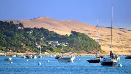 Voyage au bord de l'eau en Gironde, dans une destination prisée par les passionnés de voiliers et proches de la Dune du Pilat.