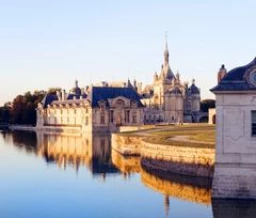 Château de Chantilly se reflétant dans les eaux calmes de l’Oise - Zecamping