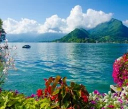 Fleurs colorées et vue sur le lac d’Annecy entouré de montagnes en Savoie - Zecamping